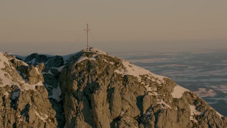 A cross sits atop a large mountain