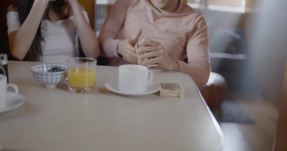 Man and woman play cards at a table