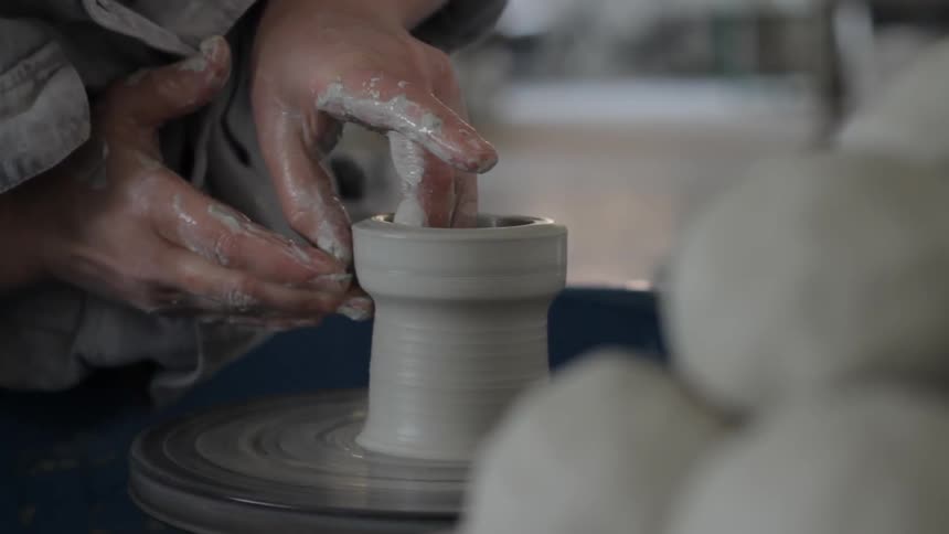 This person is preparing a pot with wet clay