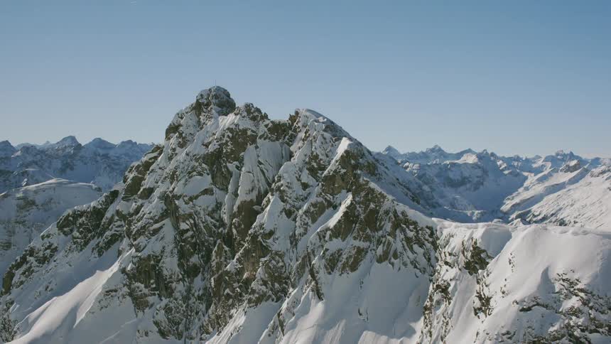 Snow covers a rocky mountain ridge