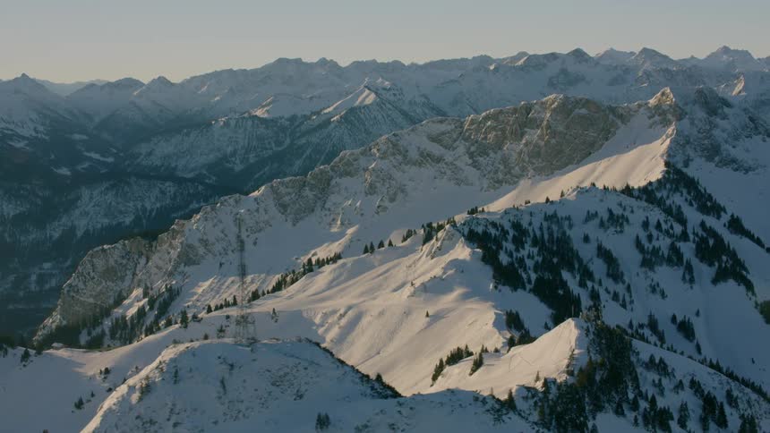 Snow covers mountain peaks and slopes on a sunny day