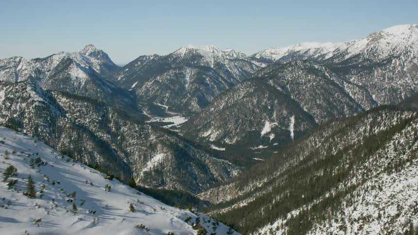 Large mountain range covered in trees and snow
