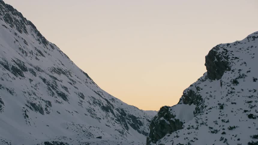 A snowy mountain is flown past
