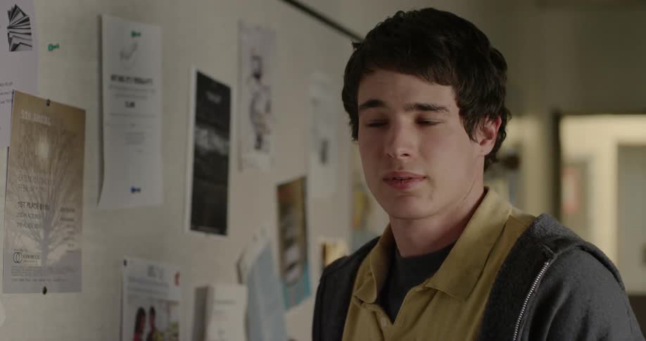 A man looks at a sign on a bulletin board