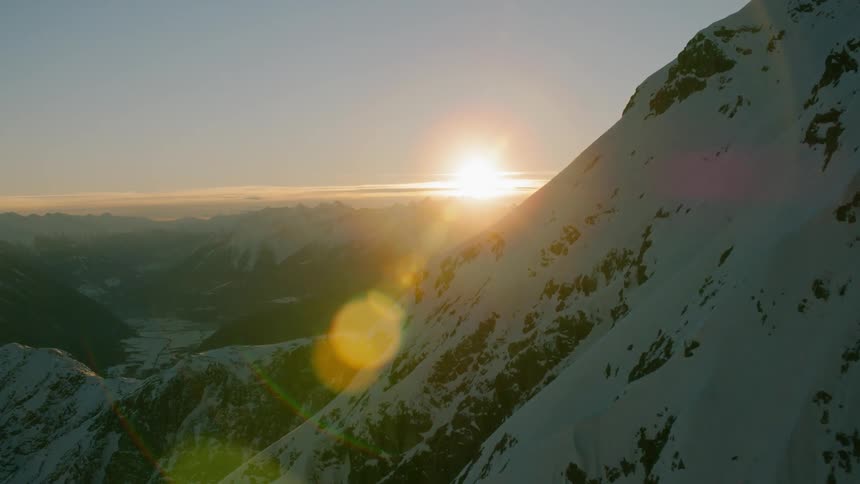 Sunset behind snowy mountains