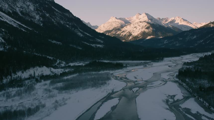 A river flows through snowy mountains