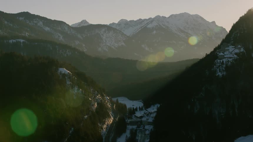 The sun shines on snow covered mountains