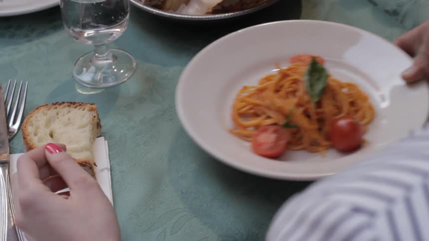 A woman is served a pasta dish
