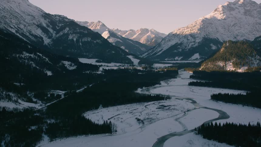 A melting river winds its way through a mountain valley