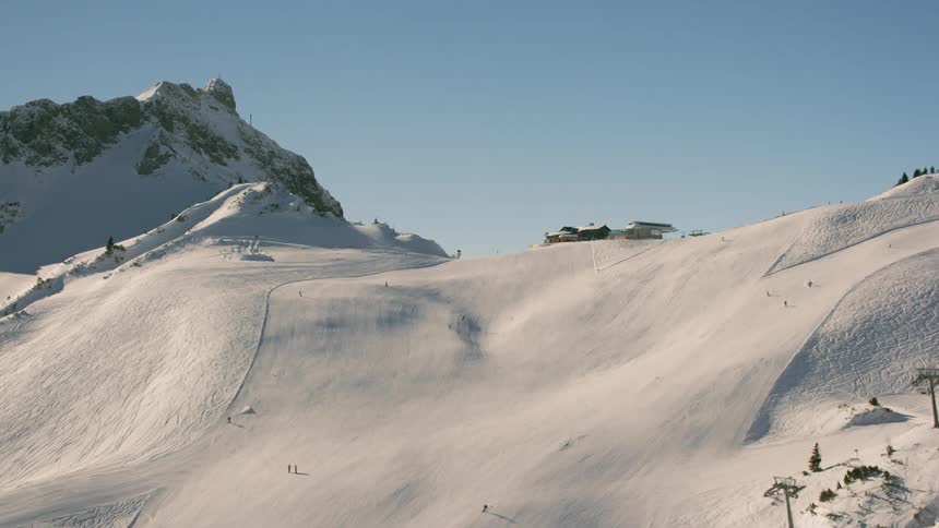 Skiers travel down slopes during the day at a ski resort