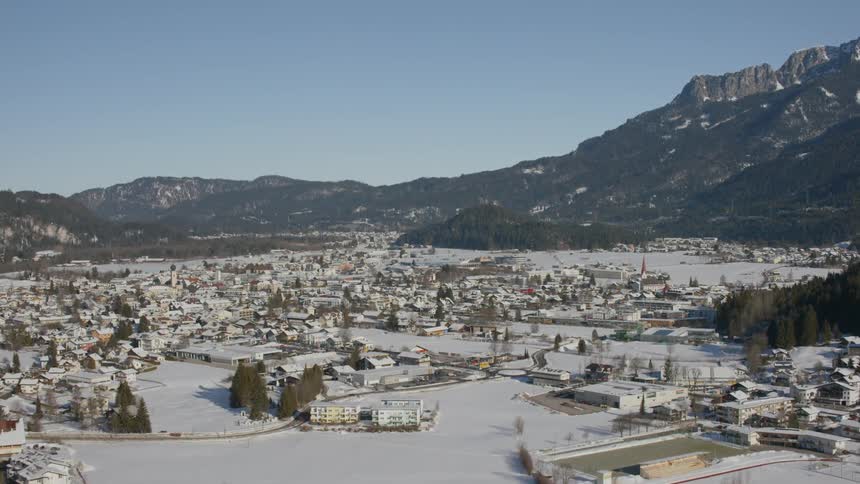 Snow covers the landscape below a mountain