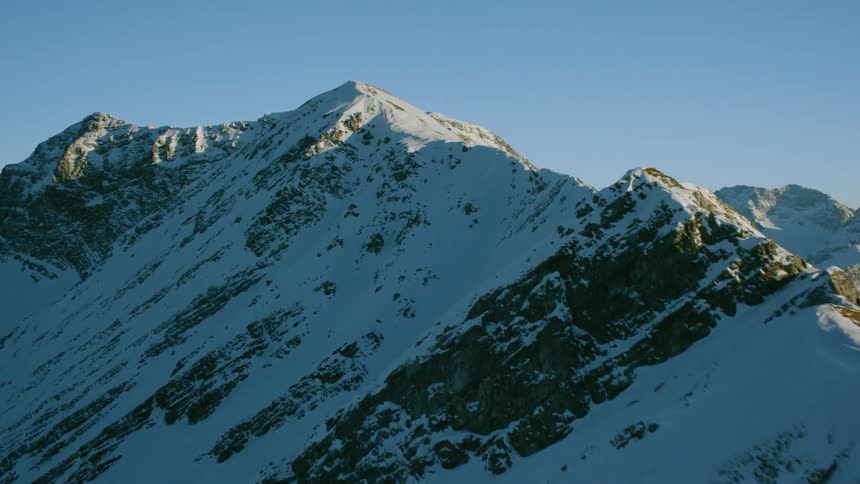 Snow covers rocky mountain ridge