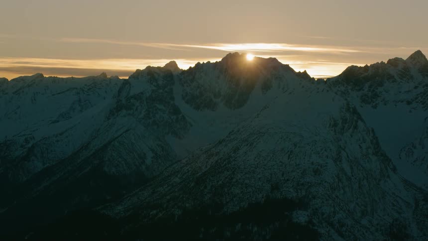 The sun is setting fast behind the mountain