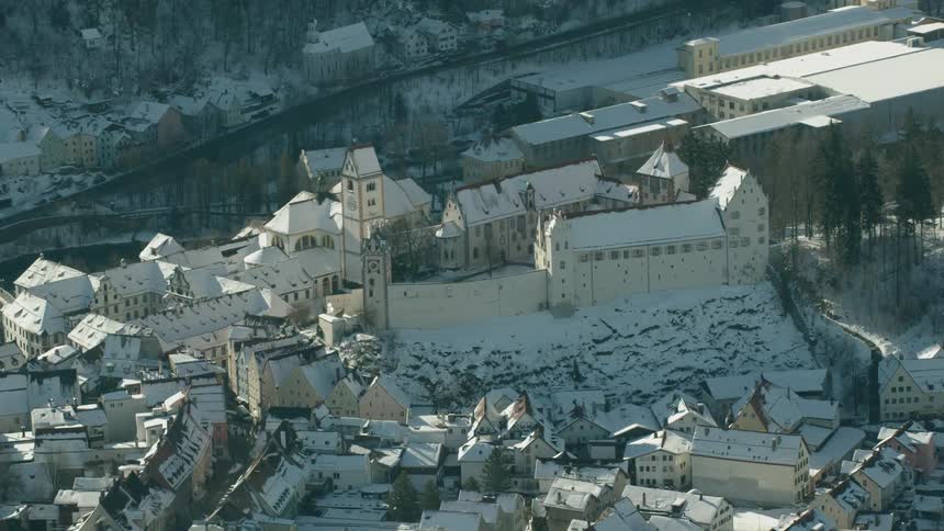 A large church and town is shown covered in snow