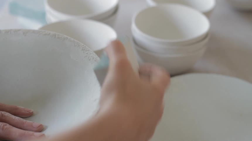 A white woman wipes down a bowl