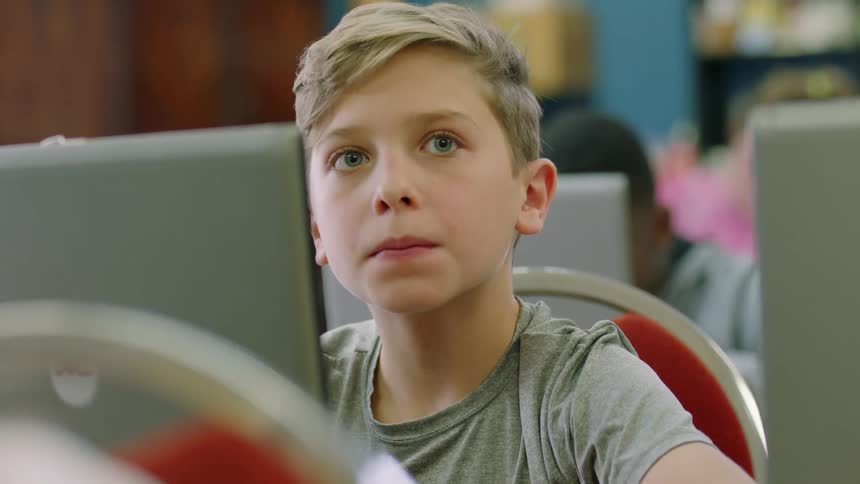 Students work on laptops in a classroom