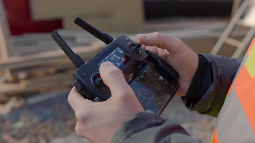 Worker holds controller on construction site