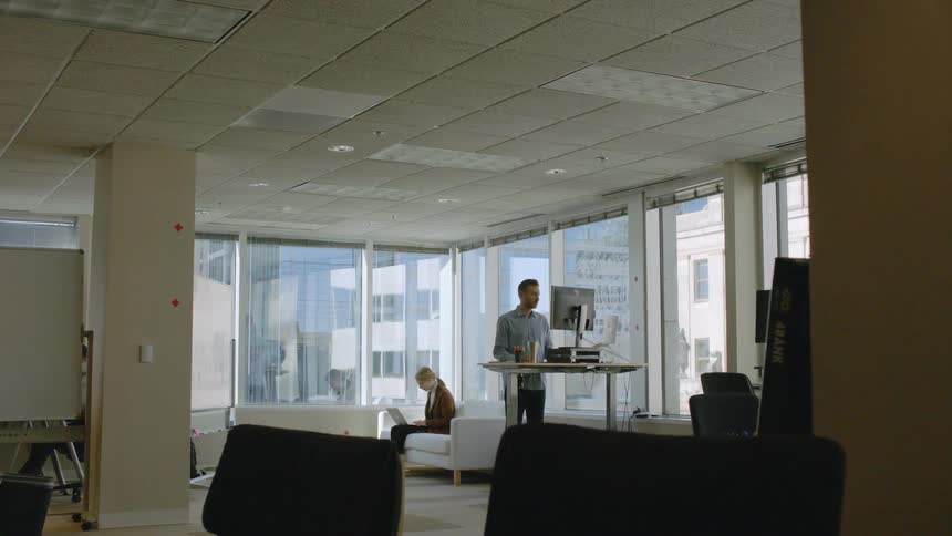 Two people work in an office lounge
