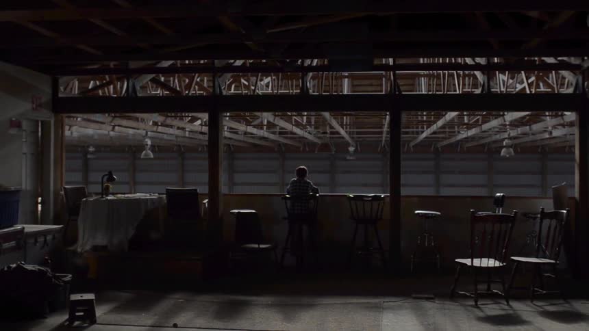 Person standing in an empty area with tables around him