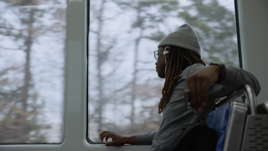A man looks out the window while riding public transit