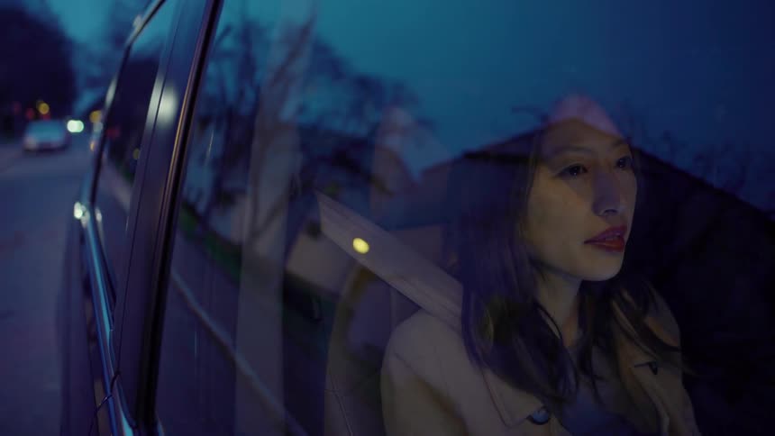 Woman rides in a vehicle at night