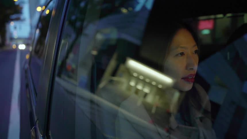 Woman sits in a vehicle as it travels down the road