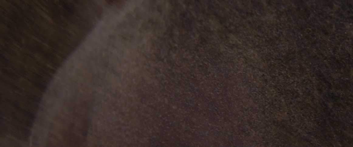 Snow falls on a brown object