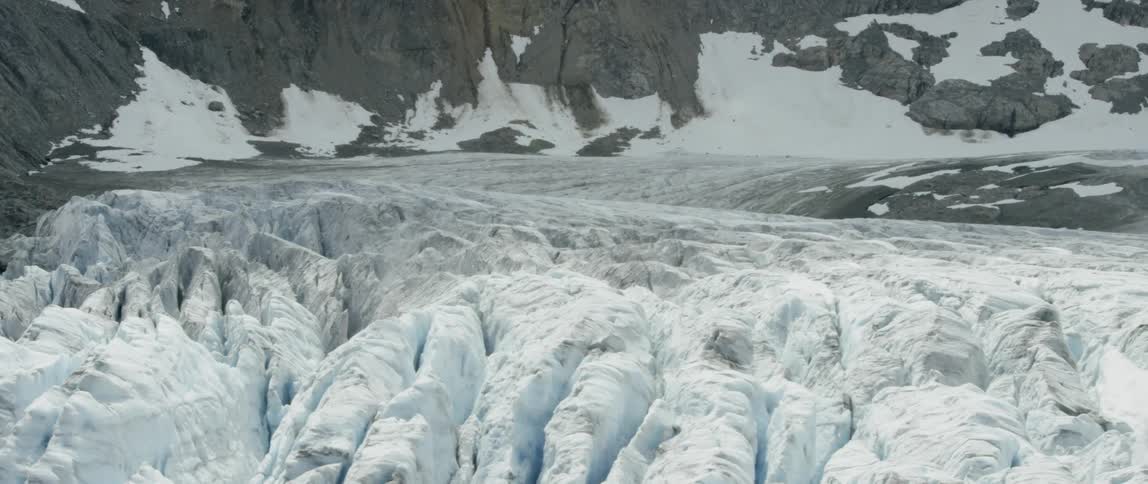 Piles of snow sit in rocky mountains