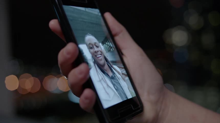 A man holds a phone playing a video