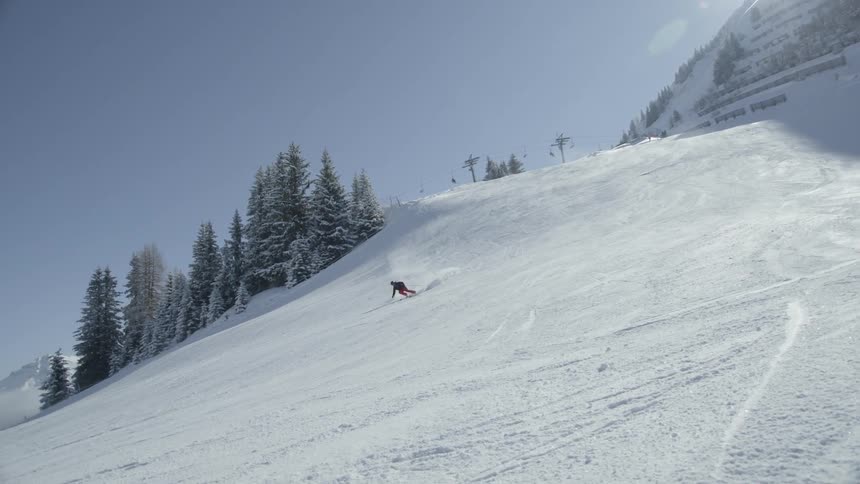 A snowboarder descends down the slope