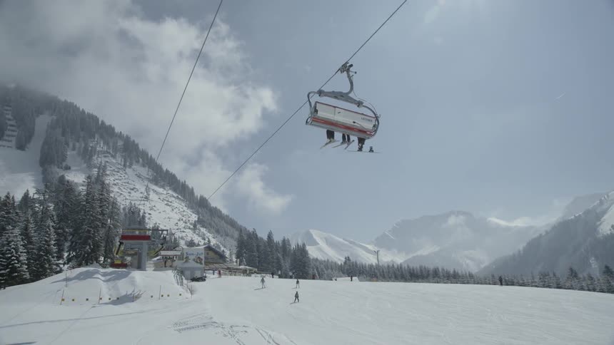 People ride ski lifts up and down the mountain