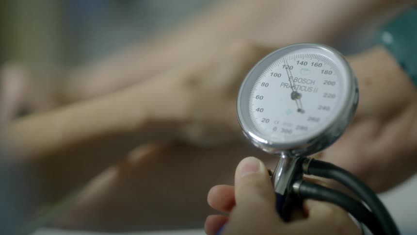 A nurse takes a man's blood pressure