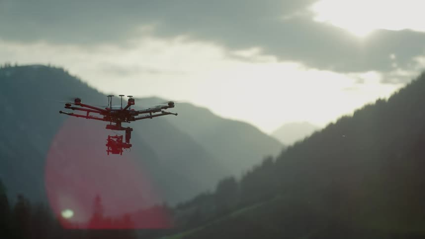 A drone is flying over a mountain setting on a cloudy day