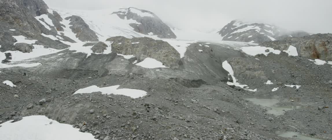 Snow covers a rocky mountainside