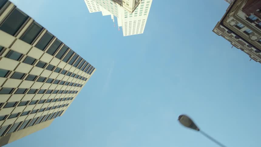 Skyscrapers in a city stretch up into a blue sky