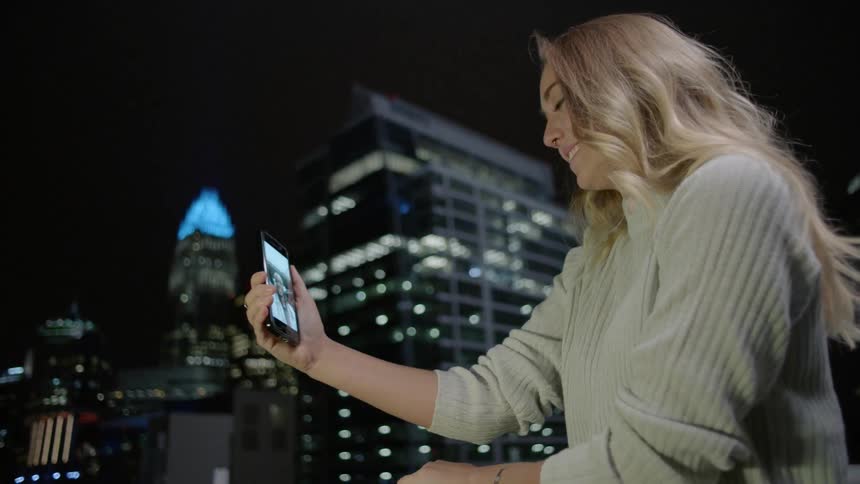A woman smiles while talking to someone on a phone