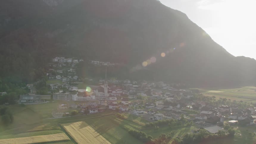 The sun shines down on a small mountain town