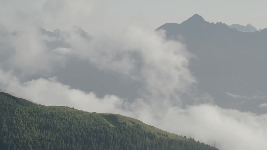 Clouds floating over forest and mountains