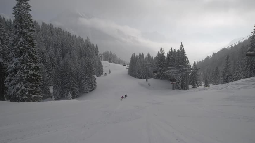 Skiers glide down a snowy mountain