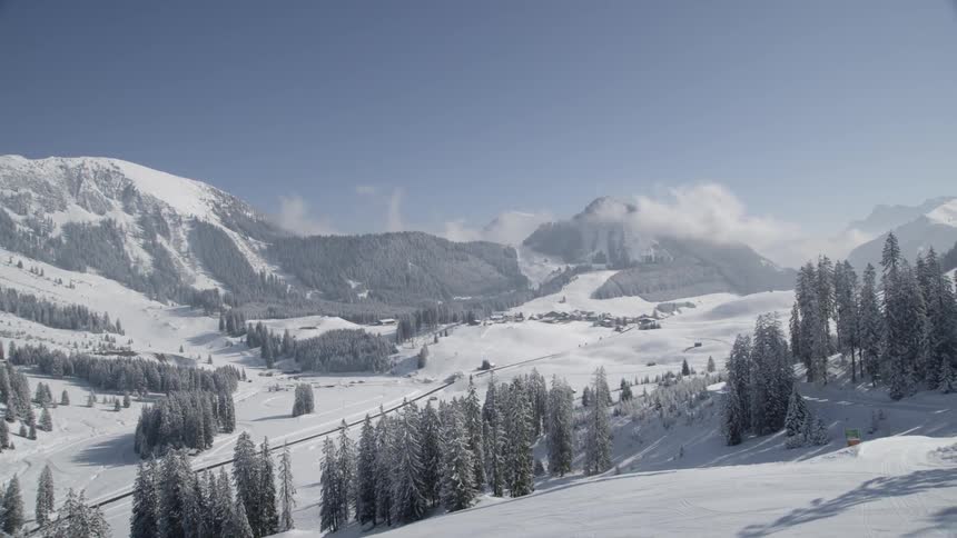 Snow and frost are covering the landscape in a mountain valley on a sunny day