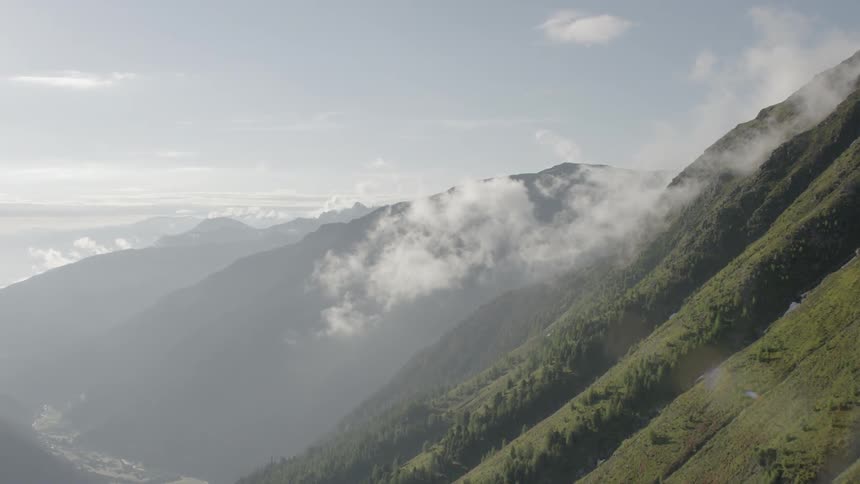 The clouds float over the green mountain