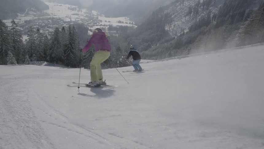 Skiers glide down a snowy mountain