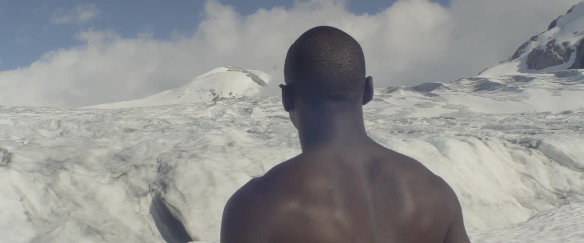 A shirtless man on a glacier