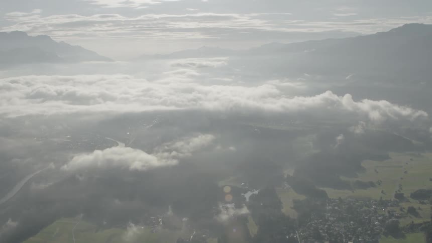 Helicopter Timelapse - Clouds over mountains and a small town