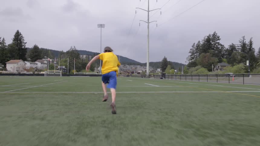 Kid sprinting on athletic field
