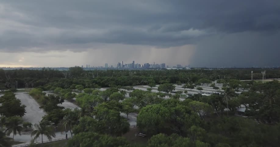 Clouds hover over a parking lot with a skyline in the distance