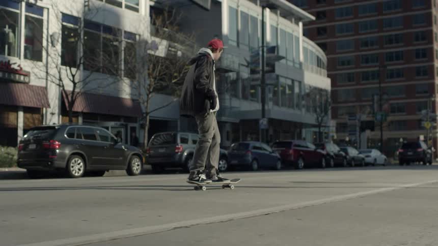 A skateboarder rides down the street