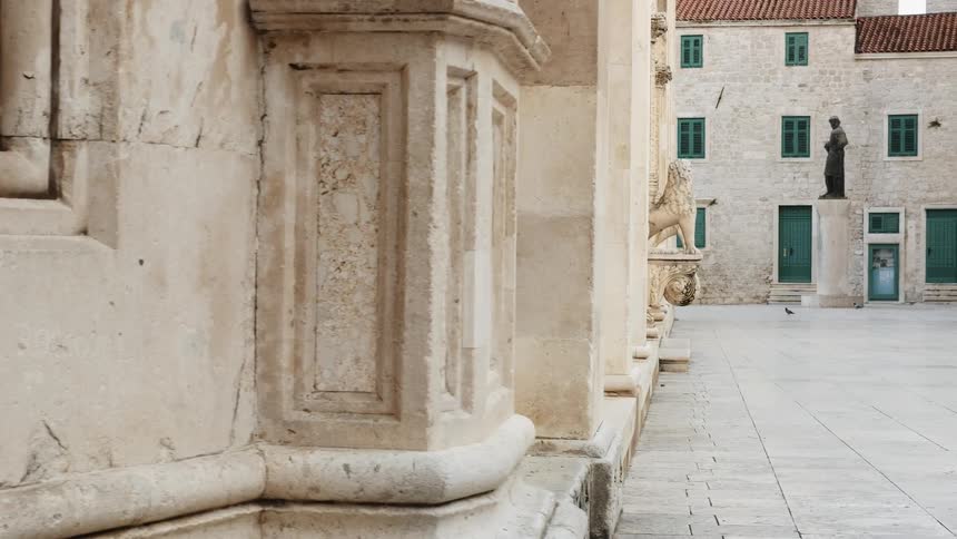Birds walk on the ground near stone statues
