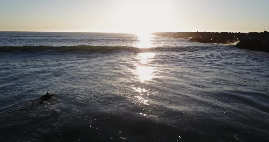 A surfer is paddling out to catch a wave