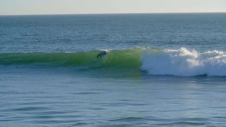 A surfer swims on the ocean